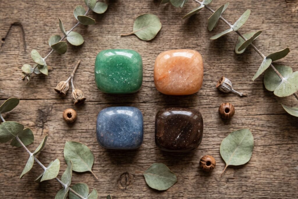 Cuatro variedades de venturina en colores verde, naranja, azul y café sobre madera natural